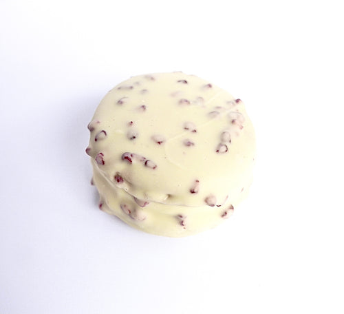 Seasonal macaron wagon wheel with macaron shell, marshmallow centre, covered in white chocolate with freeze-dried raspberry pieces