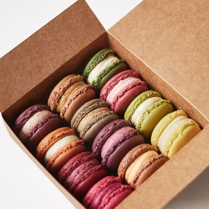 Giselle Richardson cardboard gift box of a handmade luxury French macarons selection of the flavours of the month (on white background).