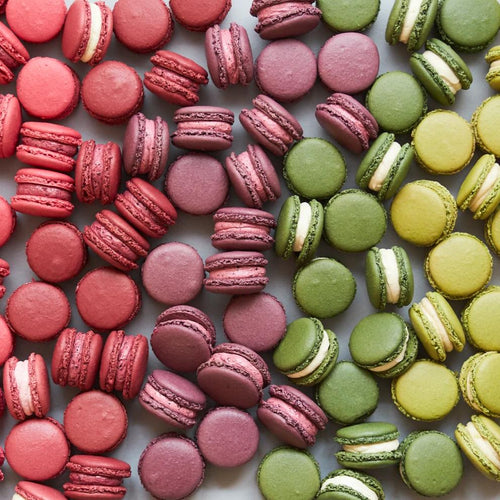 Red and green macarons on grey background