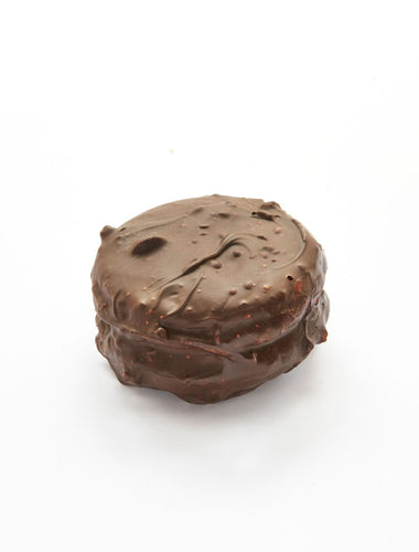Large dark chocolate-covered macaron with hazelnut filled with marshmallow