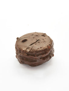 Large dark chocolate-covered macaron with hazelnut filled with marshmallow